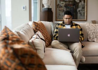 Student working on laptop while sitting on couch