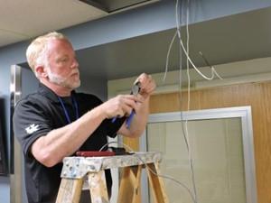 Tech team installing wires in ceiling