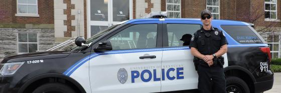 Officer standing beside a police suv.