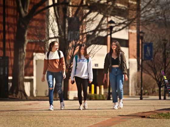 Three students walk on campus